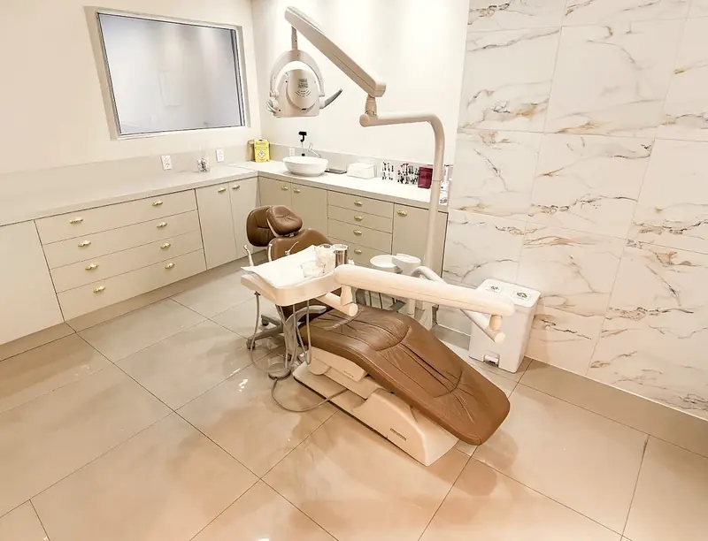 Sala de atendimento com parede de mármore e cadeira caramelo
